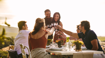 Groupe d'amis trinquant avec un couple 