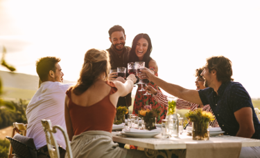 Groupe d'amis trinquant avec un couple 