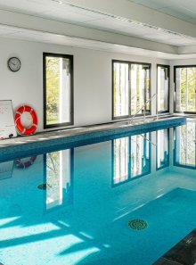 vue sur un bassin de balnéothérapie dans un espace avec de nombreuses baies vitrées