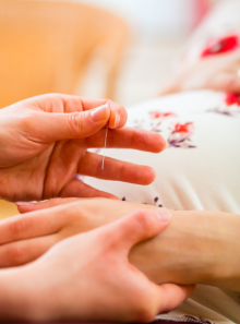 Pose d'aiguilles d'acupuncture sur la main d'une femme enceinte