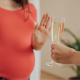 Une femme enceinte refuse une coupe de champagne