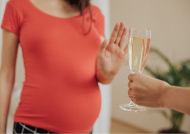 Une femme enceinte refuse une coupe de champagne